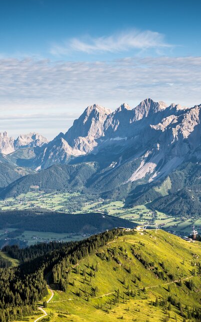 Panorama-Ausblick auf das Dachsteinmassiv und das Ennstal bei klarem Himmel oberhalb von Schladming. | © Josh Absenger